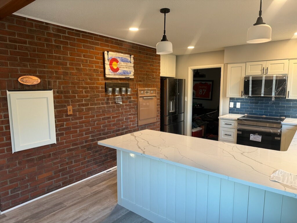 Kitchen island with quartz countertop and brick accent wall
